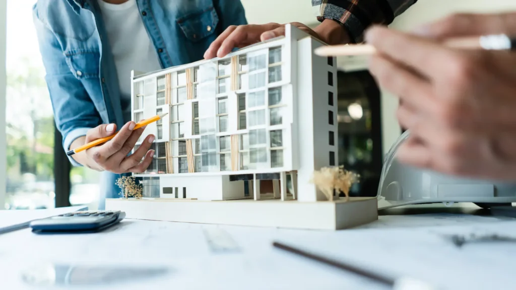 People examining a model apartment building
